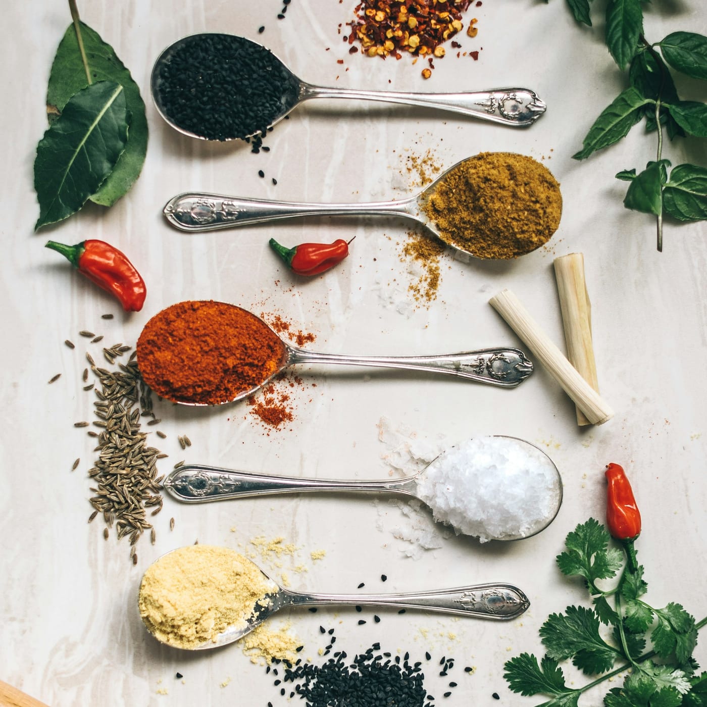 Spoons of colorful cooking spices — paprika, curry, salt and more